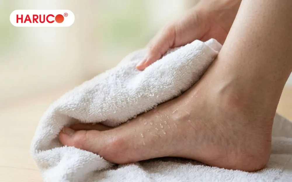 Lau khô bàn chân bằng khăn mềm sau khi thực hiện ngâm chân